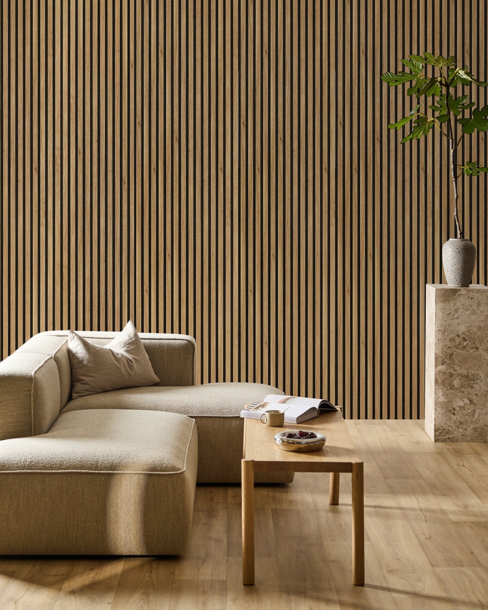 Minimalist living room featuring a beige sectional, wood coffee table, plant, and a WoodUpp Akupanel Essential acoustic panel in English Oak (240x60 cm) as an accent wall.